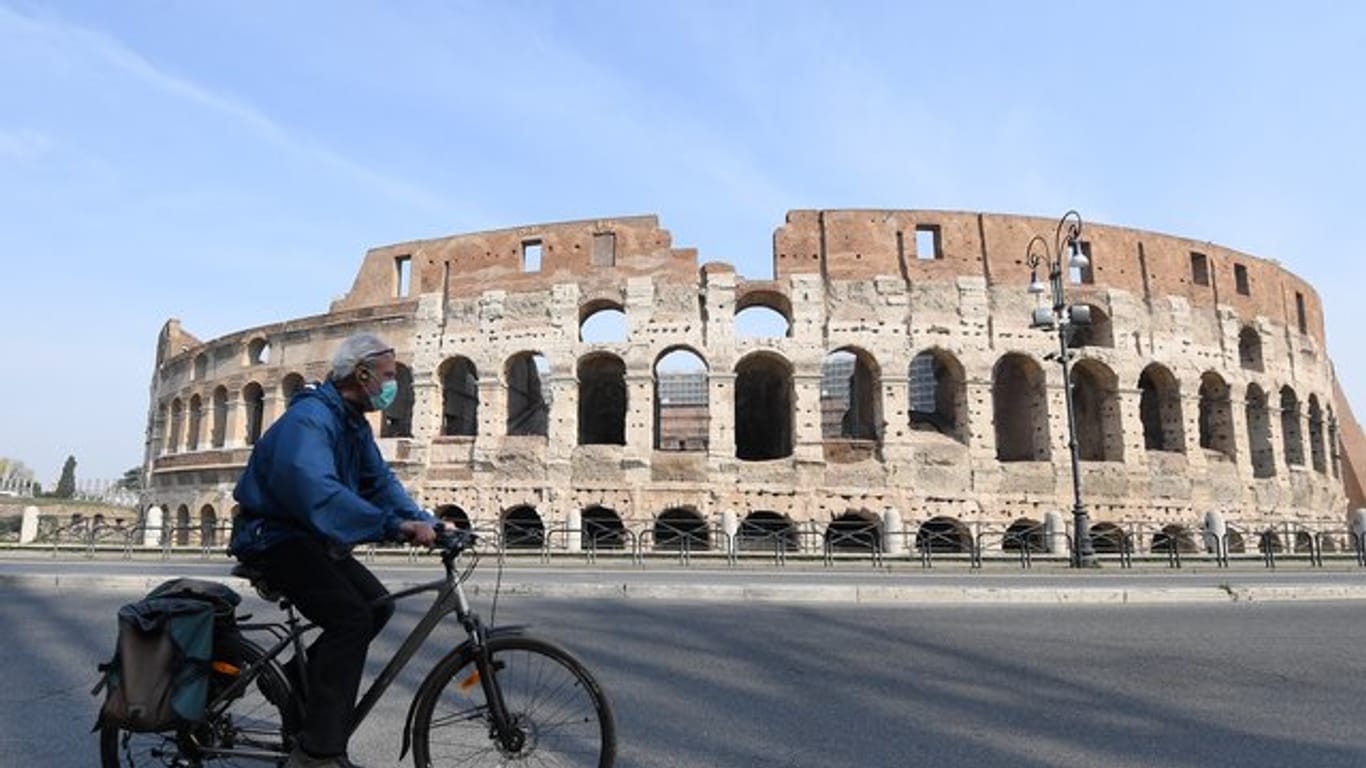 Fahrt mit Gesichtsmaske vor dem Kolosseum in Rom.