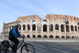 Fahrt mit Gesichtsmaske vor dem Kolosseum in Rom.
