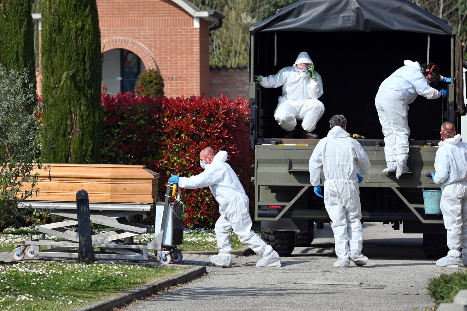 Menschen in Schutzanzügen transportieren einen Sarg mit einer Leiche eines Corona-Patienten auf den Friedhof von Ferrara: Das Land hatte am Samstag an nur einem Tag fast 800 Tote vermeldet.