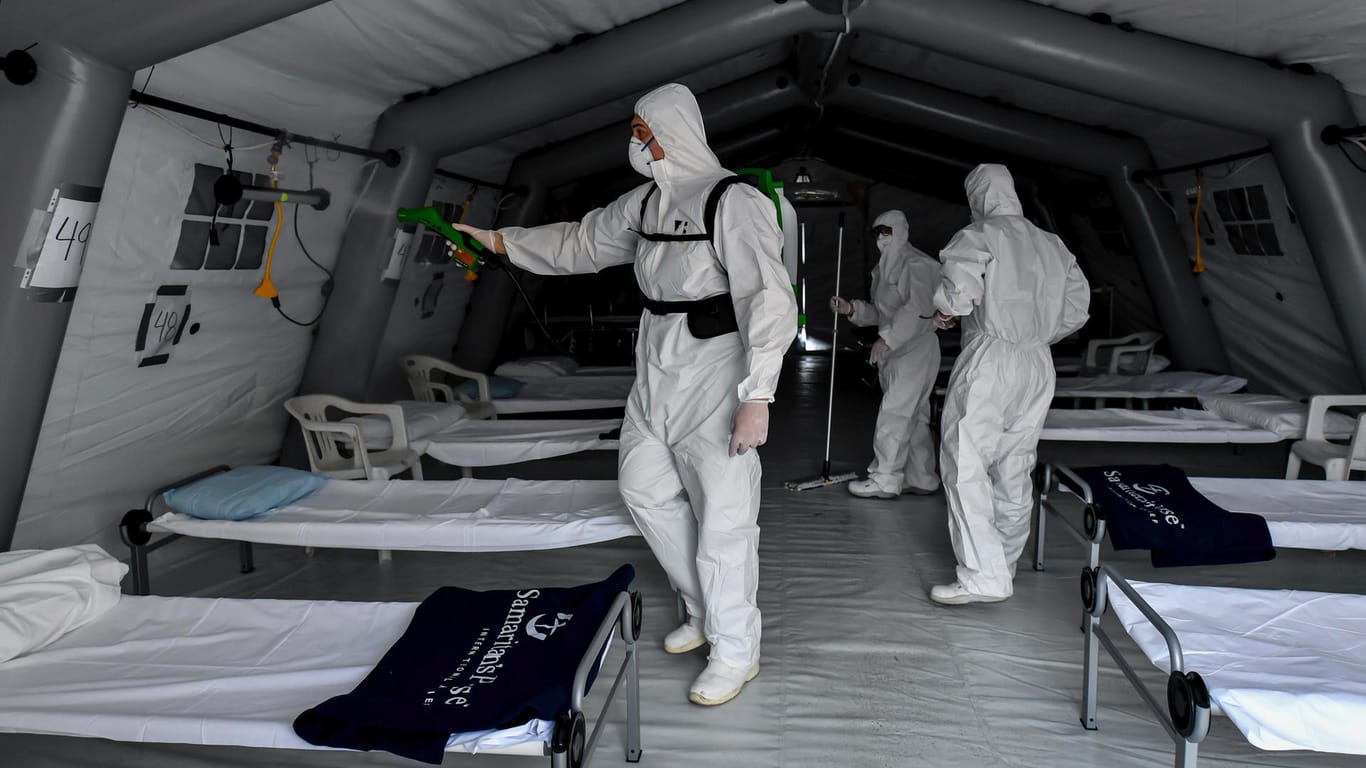 Mitarbeiter reinigen ein Feldkrankenhaus in Italien.