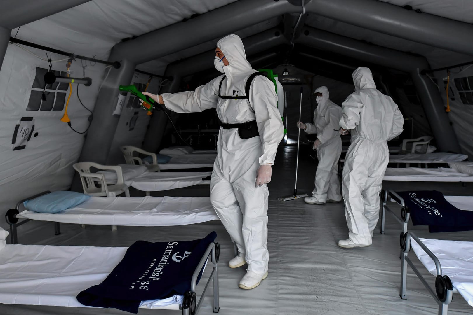 Mitarbeiter reinigen ein Feldkrankenhaus in Italien.