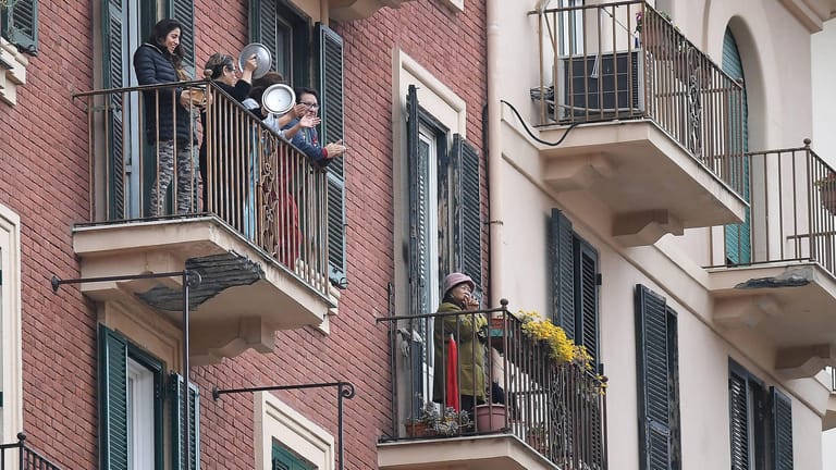 Bewohner applaudieren auf Balkonen ihrer Wohnungen in der Innenstadt von Mailand vorbeifahrenden Einsatzfahrzeugen.