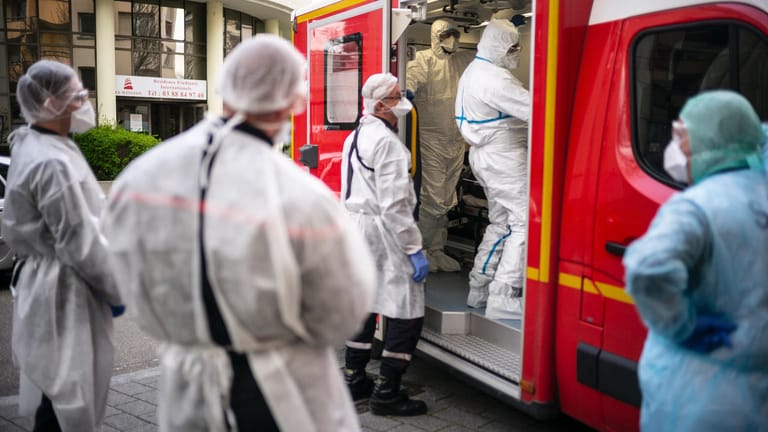Straßburg im Elsass: Rettungskräfte in Schutzanzügen kümmern sich in einem Krankenwagen um einen Mann mit Atemnot. Die Region Grand Est ist einer der Epidemie-Brennpunkte in Frankreich.