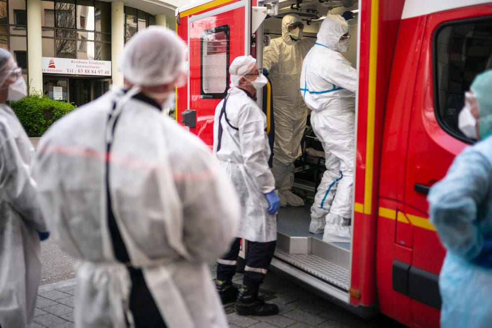 Straßburg im Elsass: Rettungskräfte in Schutzanzügen kümmern sich in einem Krankenwagen um einen Mann mit Atemnot. Die Region Grand Est ist einer der Epidemie-Brennpunkte in Frankreich.