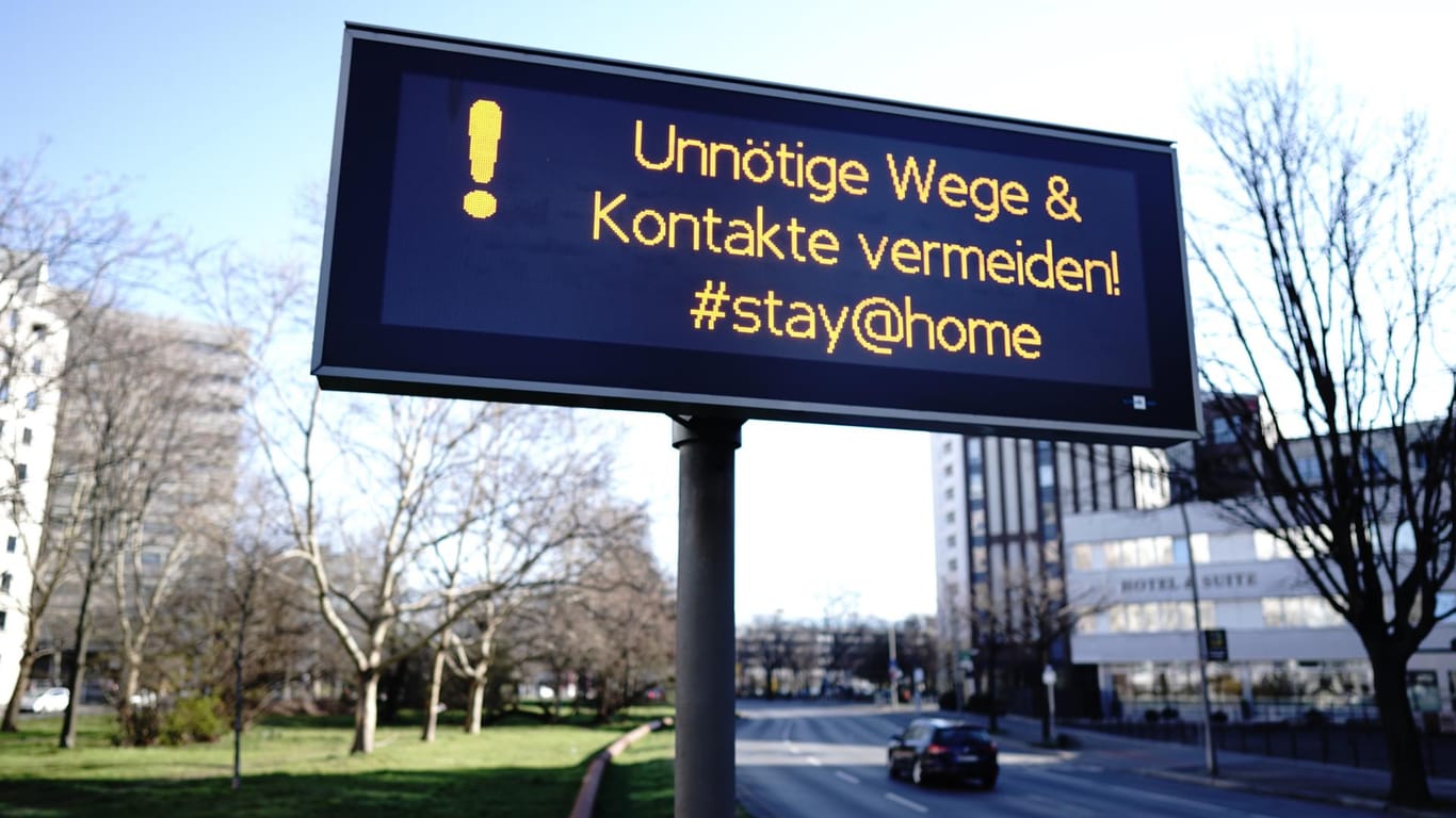 Ein Schild mit der Aufschrift "Unnötige Wege & Kontakte vermeiden! #stay@home": In Berlin wird das öffentliche Leben weiter erheblich eingeschränkt.