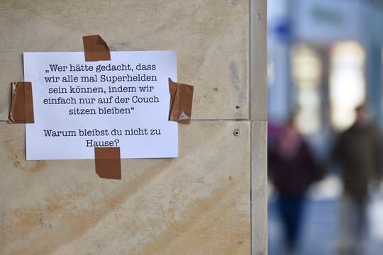 Botschaft auf einem Blatt Papier an einer Hauswand in Erfurt: "Warum bleibst Du nicht zu Hause?".