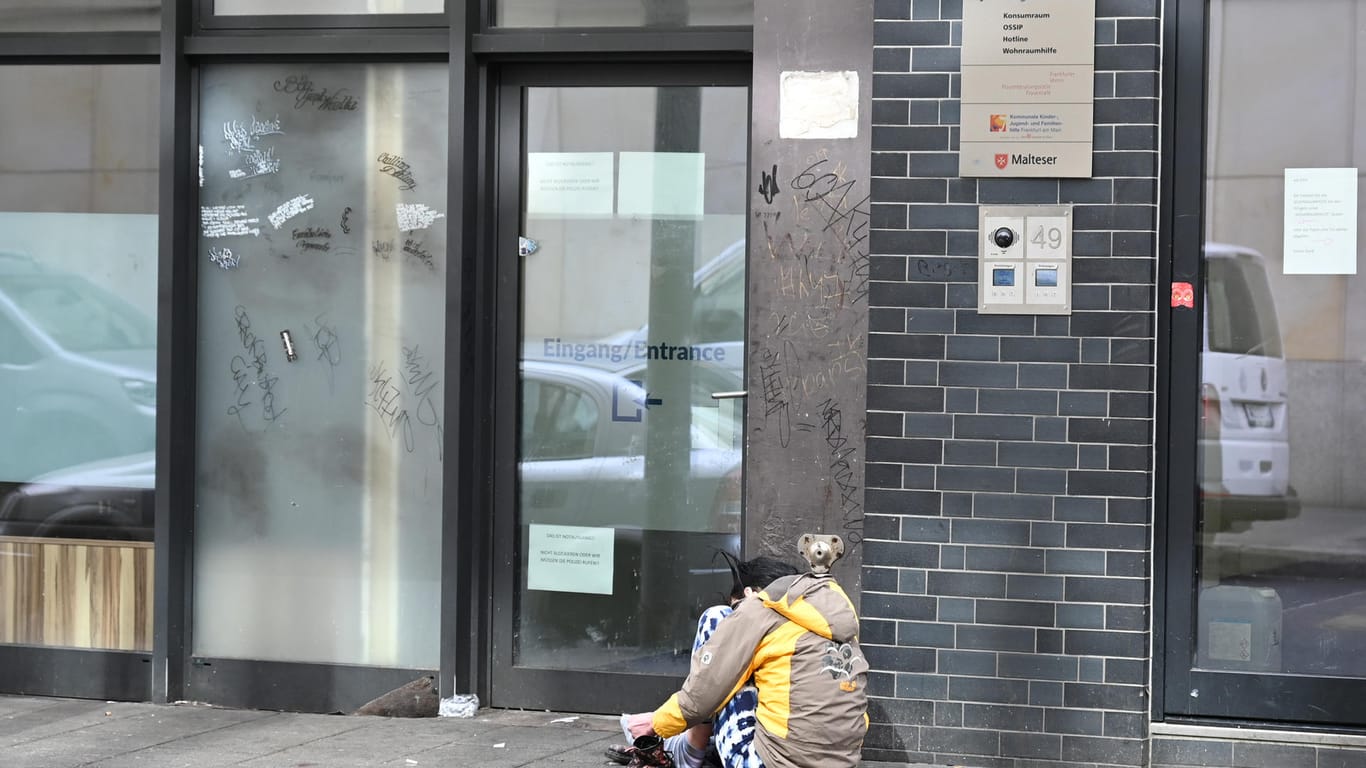 Eine drogensüchtige Frau kauert im Frankfurter Bahnhofsviertel auf dem Asphalt vor dem Konsumraum der Integrativen Drogenhilfe: Die Drogenhilfe in Frankfurt arbeitet auch während der Corona-Krise weiter.
