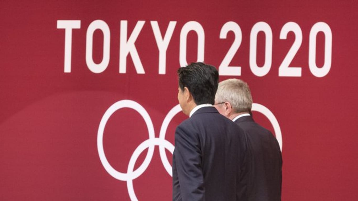 Japans Premierminister Shinzo Abe (l) und IOC-Präsident Thomas Bach sollen sich auf die Verschiebung der Olympischen Spiele in Tokio um ein Jahr verständigt haben.