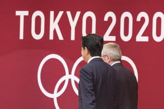 Japans Premierminister Shinzo Abe (l) und IOC-Präsident Thomas Bach sollen sich auf die Verschiebung der Olympischen Spiele in Tokio um ein Jahr verständigt haben.