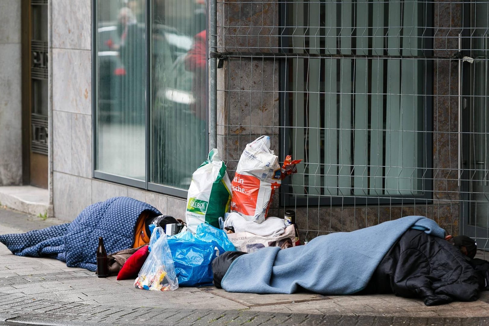 Obdachlose schlafen auf einer Straße in Köln: In der Domstadt sind wegen der Coronavirus-Pandemie Hilfsangebote teilweise eingeschränkt worden.