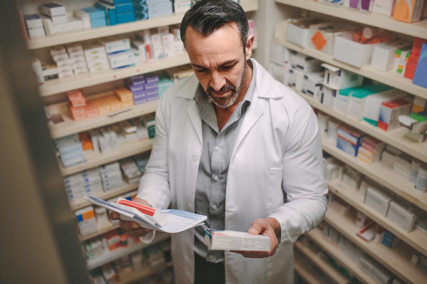 Apotheker mit einem Rezept in der Hand: Apotheken beobachten derzeit eine erhöhte Nachfrage nach Medikamenten.