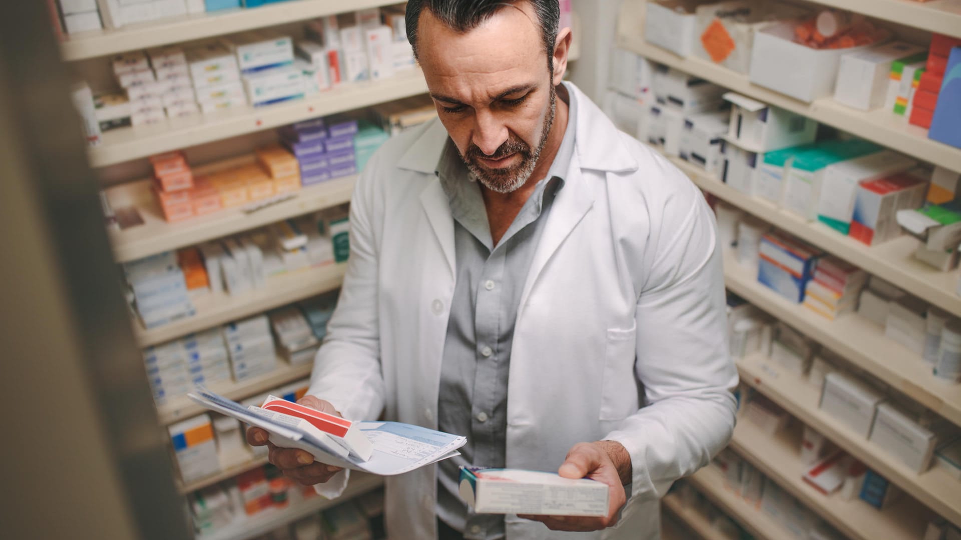 Apotheker mit einem Rezept in der Hand: Apotheken beobachten derzeit eine erhöhte Nachfrage nach Medikamenten.