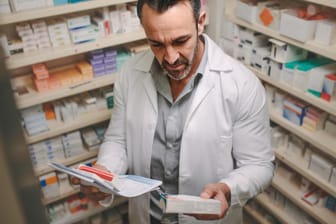Apotheker mit einem Rezept in der Hand: Apotheken beobachten derzeit eine erhöhte Nachfrage nach Medikamenten.