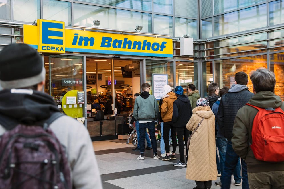Menschen stehen Schlange vor einem Edeka in Berlin: Trotzdem reagieren viele Supermärkte mit verkürzten Öffnungszeiten.