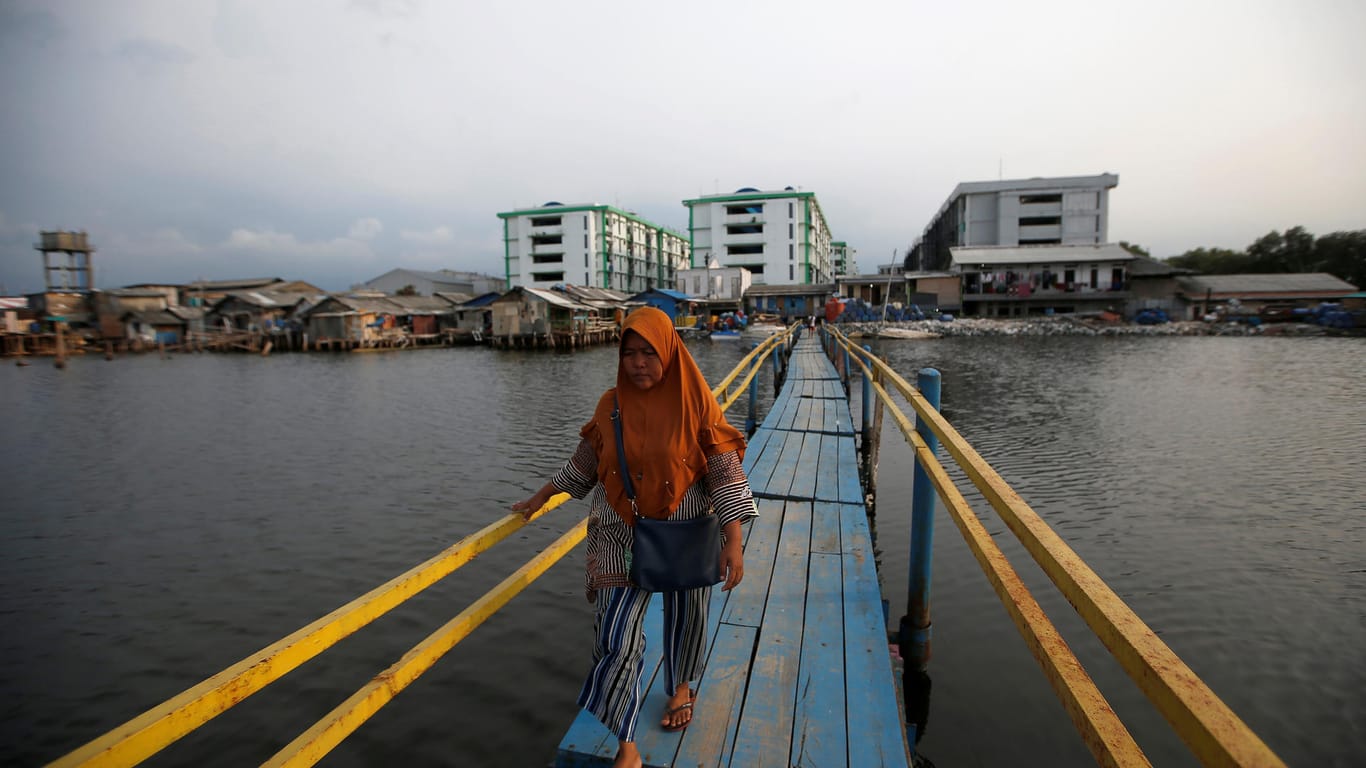 Eine Frau überquert eine Brücke in Muara Baru (Jakarta, Indonesien): Der Anstieg des Meeresspiegels macht den Bewohnern Jakartas schon heute zu schaffen.
