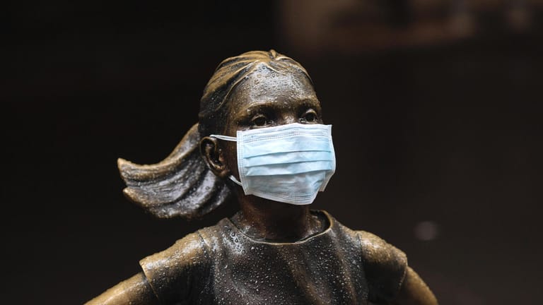 Selbst die Statue "Angstloses Mädchen" vor der Börse in New York trägt nun einen Mundschutz.