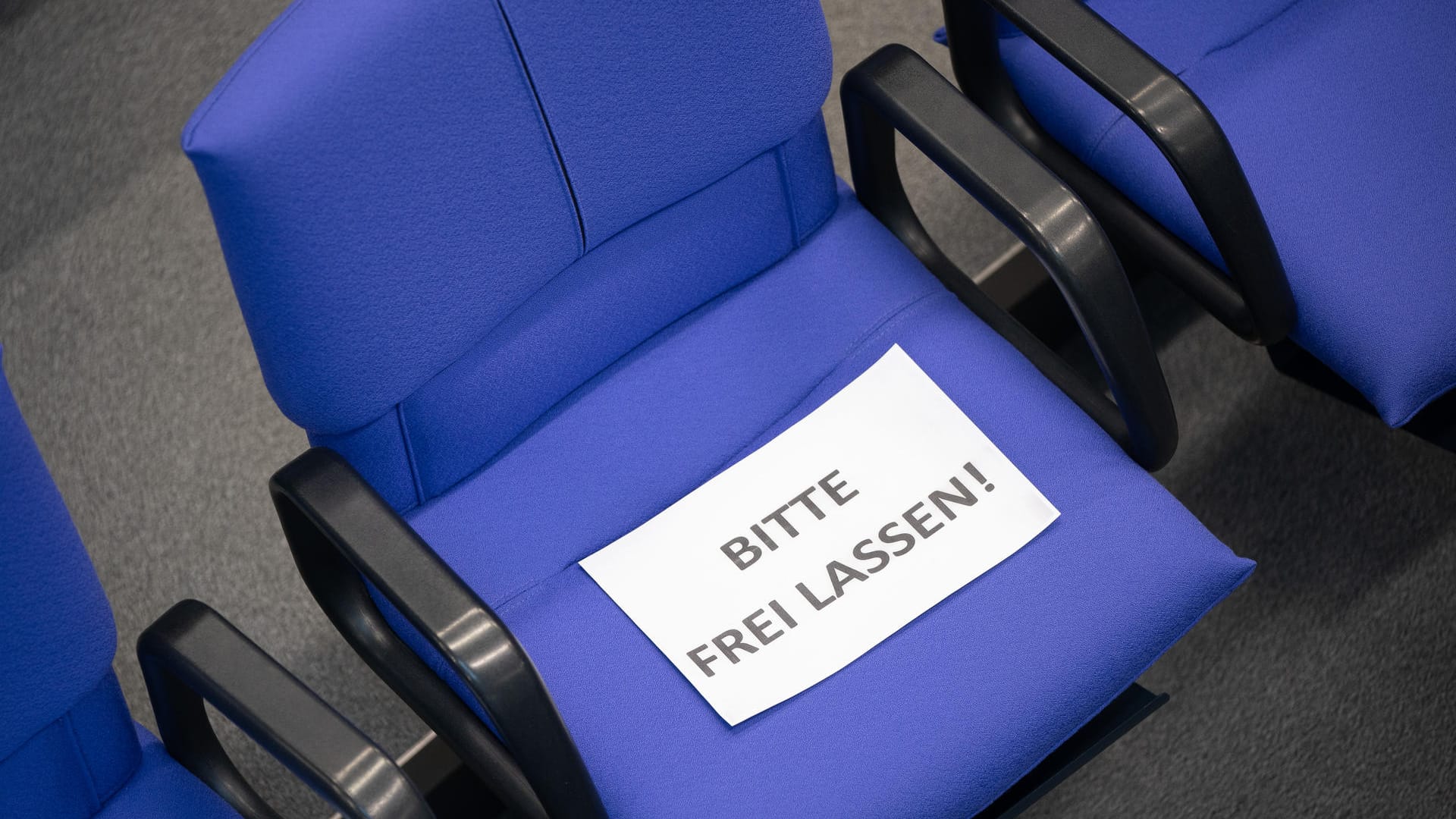 "Bitte frei lassen!" steht auf einem Stuhl im Plenarsaal: Die Abgeordneten werden heute wegen des Coronavirus sehr viel weiter voneinander entfernt sitzen.