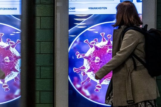 Derzeit überall präsent - das Coronavirus, wie hier auf einer Grafik im Bahnhof Alexanderplatz.