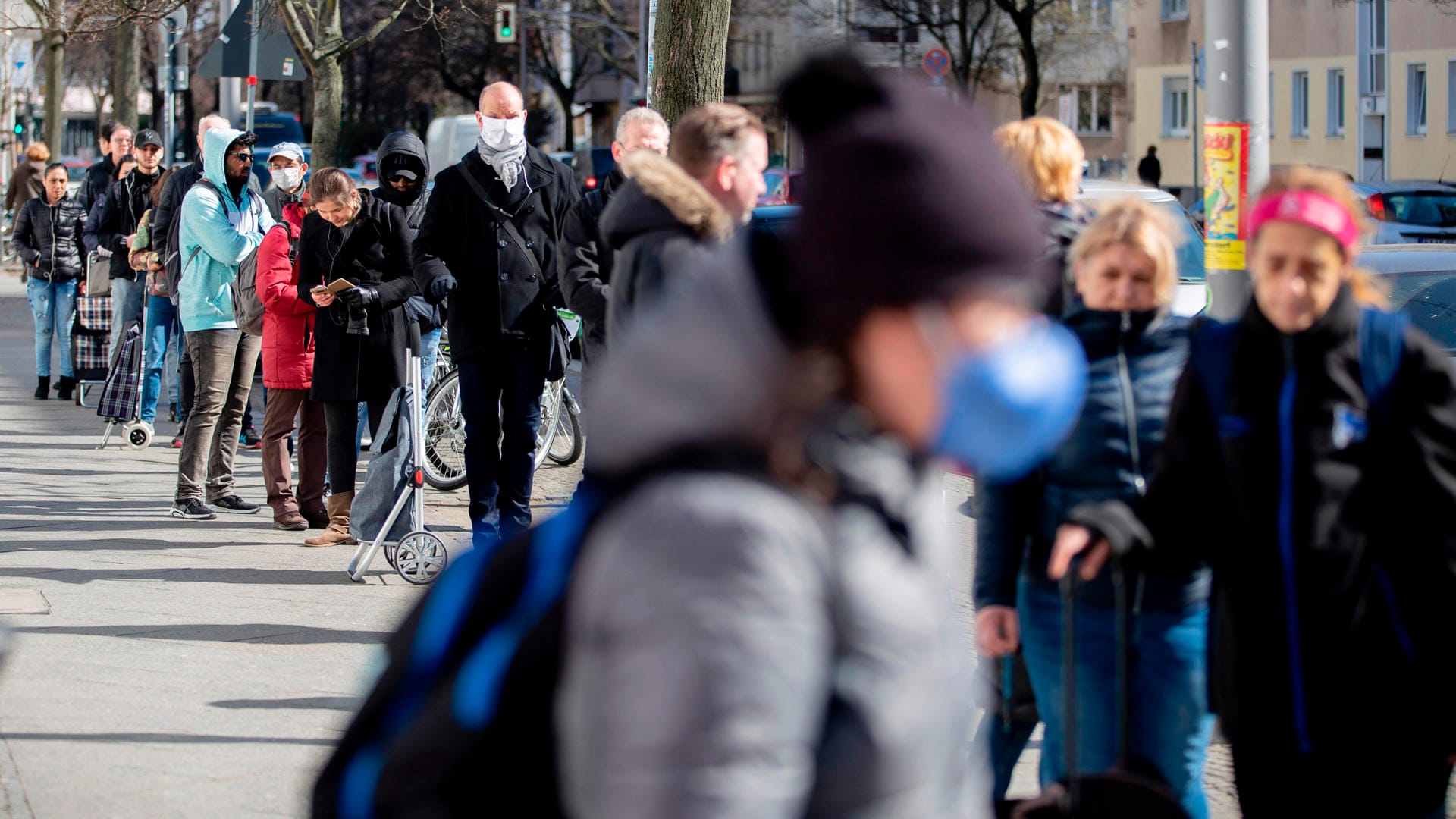 Menschen stehen in einer Schlange vor einem Supermarkt: Die Zahlen des RKI sind meist mehrere Tage alt.