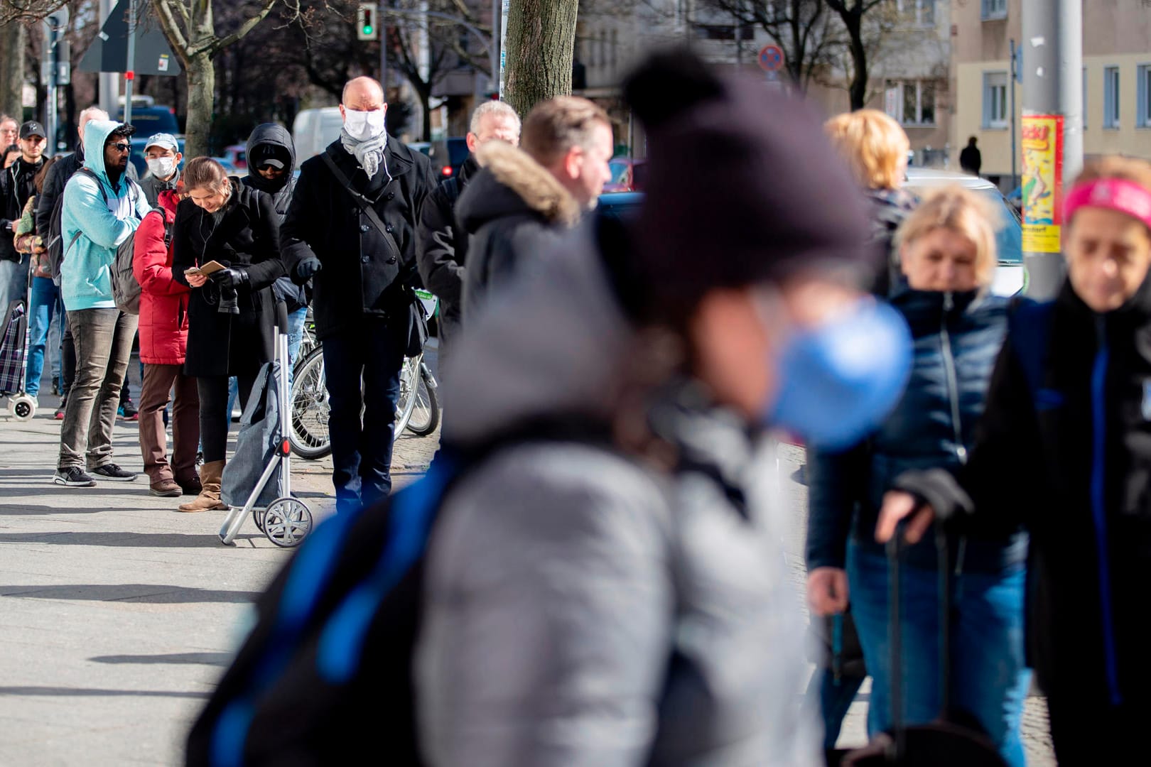 Menschen stehen in einer Schlange vor einem Supermarkt: Die Zahlen des RKI sind meist mehrere Tage alt.