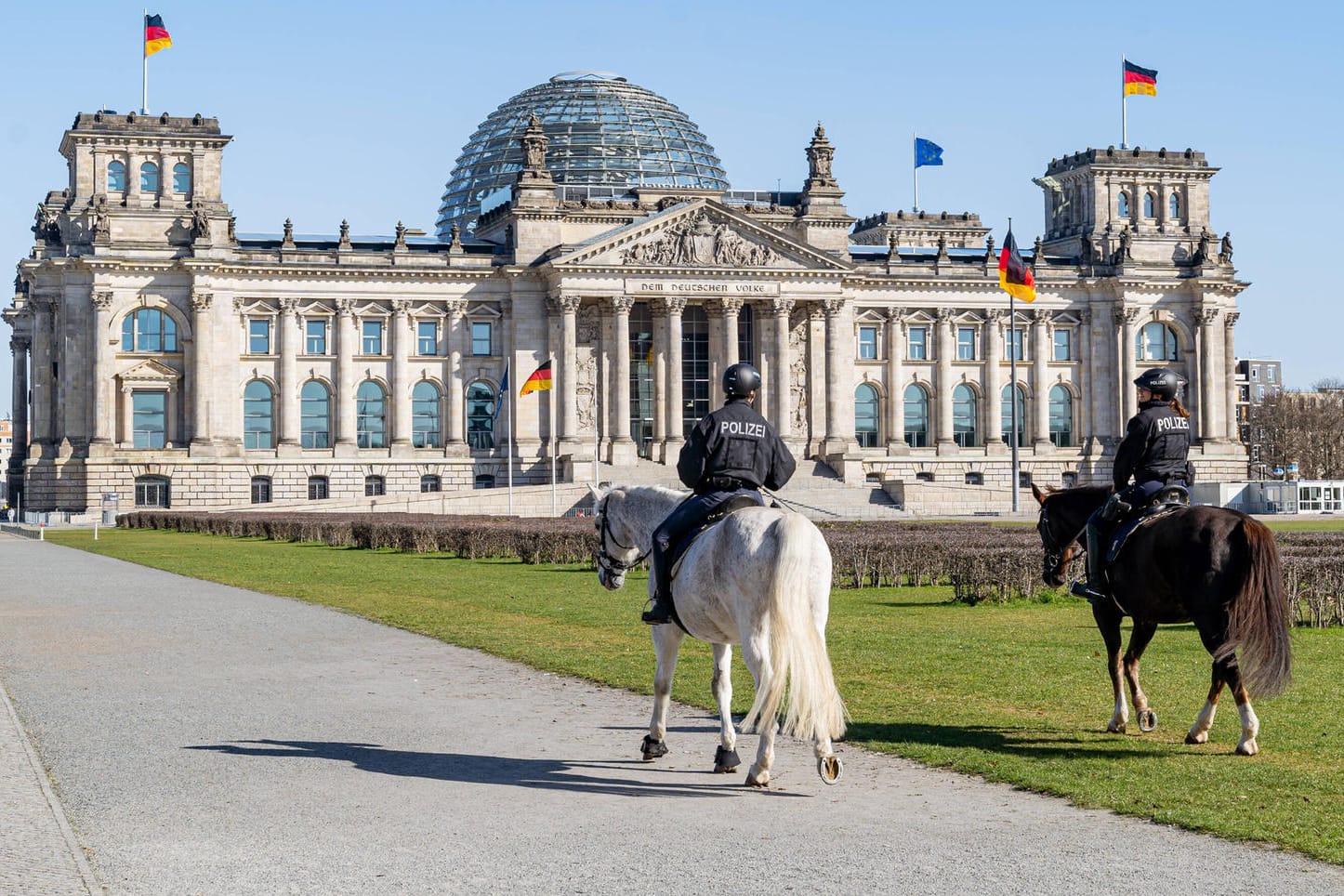 Reiterstaffel auf Patrouille vor dem Reichstag: In Berlin darf man noch joggen, aber nicht mehr im Park in der Sonne sitzen.
