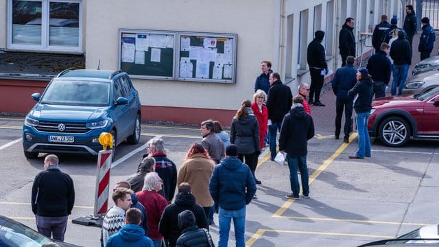 Hier ist Geduld gefragt: Apotheker und Mitarbeiter von Versorgungsbetrieben stehen auf dem Gelände des Zuckerwerks in Anklam in einer langen Schlange am Verkaufsbüro an.