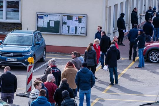 Hier ist Geduld gefragt: Apotheker und Mitarbeiter von Versorgungsbetrieben stehen auf dem Gelände des Zuckerwerks in Anklam in einer langen Schlange am Verkaufsbüro an.