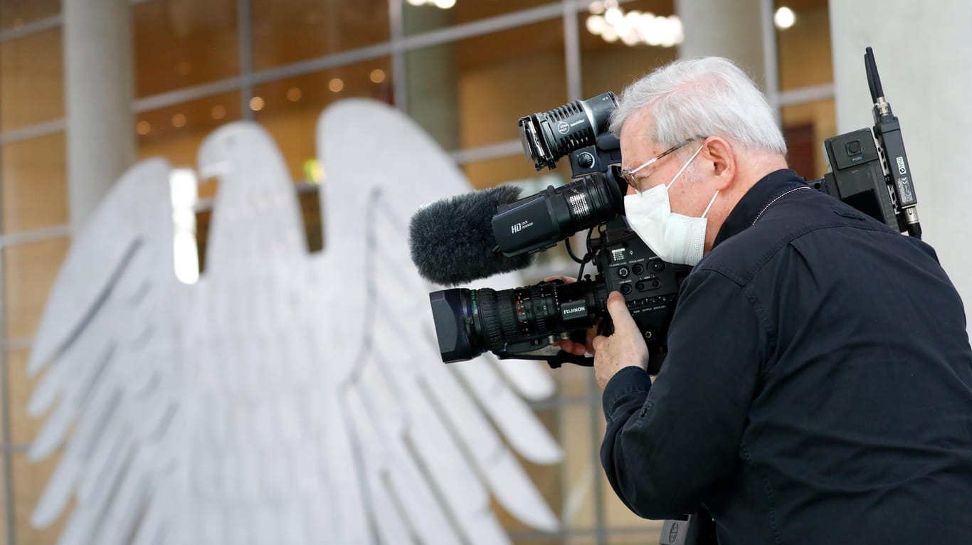 Besondere Vorsichtsmaßnahmen: Ein Kameramann filmt die Sitzung im Plenum des Bundestages.