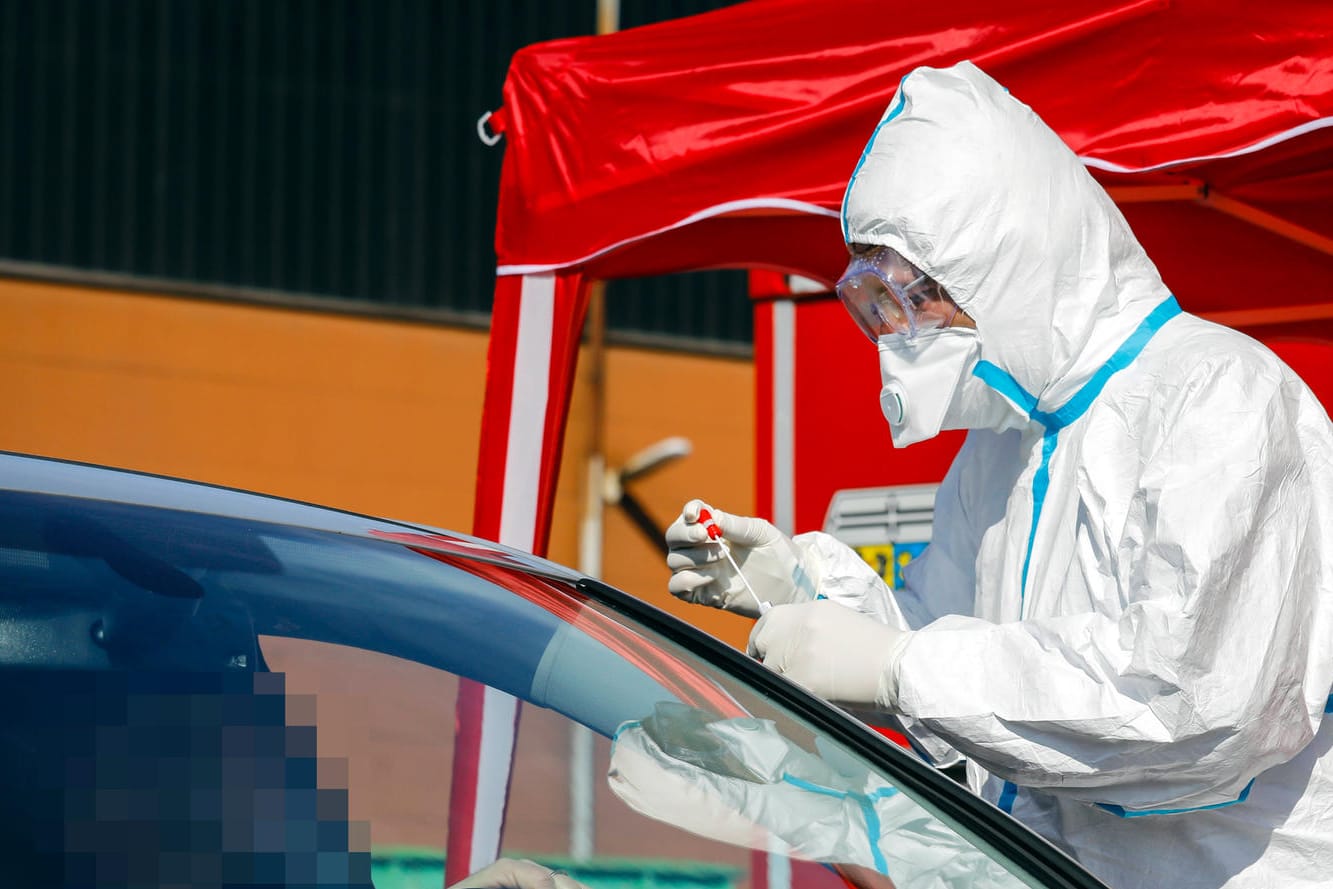 An einer mobilen Teststation entnimmt ein Arzt einen Abstrich durch das Autofenster: In Rheinland-Pfalz wurden die Abstriche auf einem Parkplatz genommen - mit überraschendem Ergebnis. (Symbolbld)