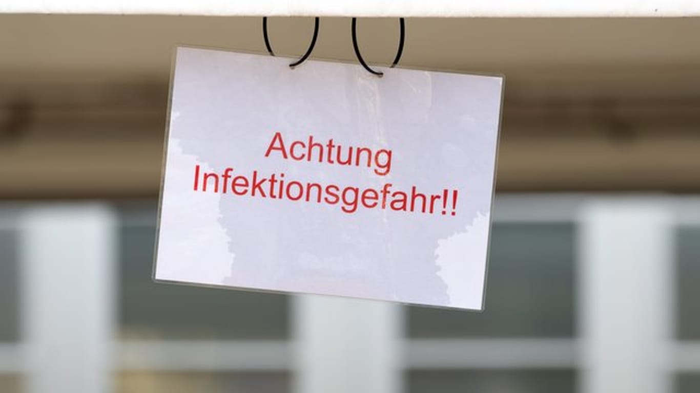 Ein Schild mit der Aufschrift "Achtung Infektionsgefahr!" an einem Johanniter-Zelt in Brandenburg.