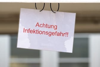 Ein Schild mit der Aufschrift "Achtung Infektionsgefahr!" an einem Johanniter-Zelt in Brandenburg.