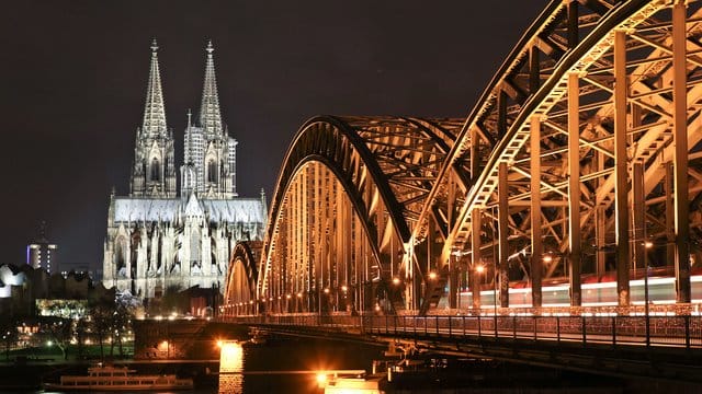 Der Dom in Köln und die Hohenzollernbrücke sind erleuchtet.