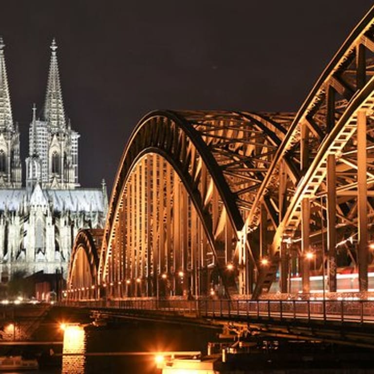 Der Dom in Köln und die Hohenzollernbrücke sind erleuchtet.