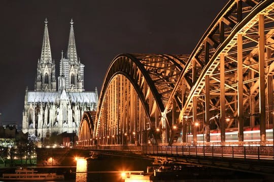 Der Dom in Köln und die Hohenzollernbrücke sind erleuchtet.