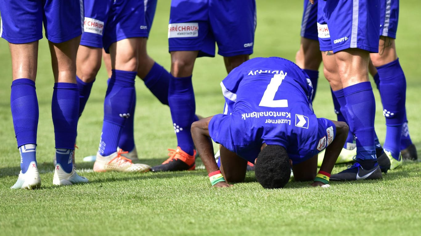 Symbolbild: Ein Fußballer betet im Vorfeld eines Spiels.