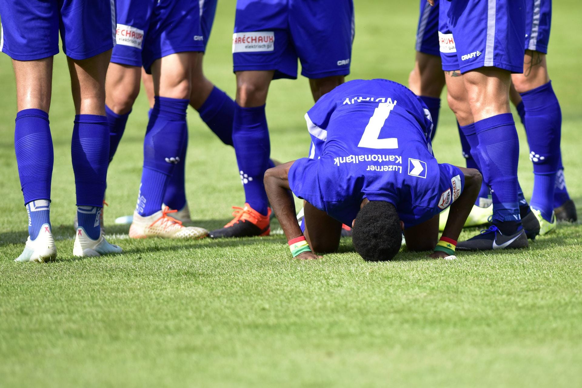 Symbolbild: Ein Fußballer betet im Vorfeld eines Spiels.