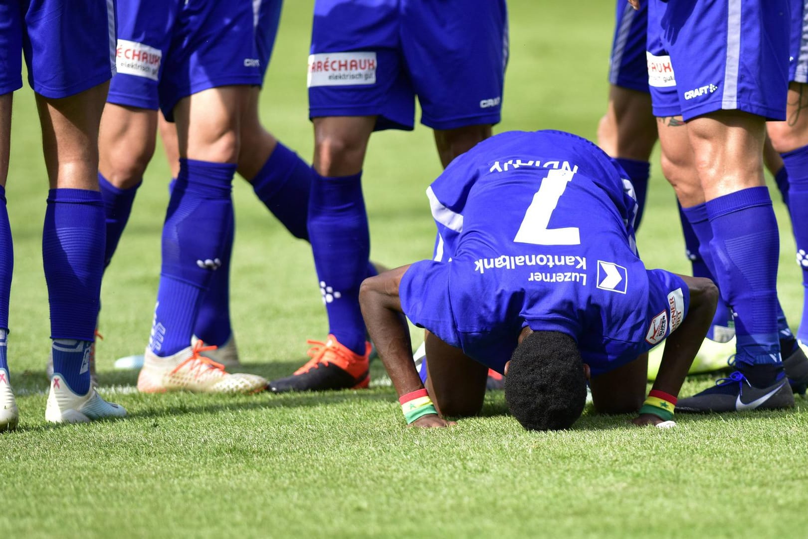 Symbolbild: Ein Fußballer betet im Vorfeld eines Spiels.