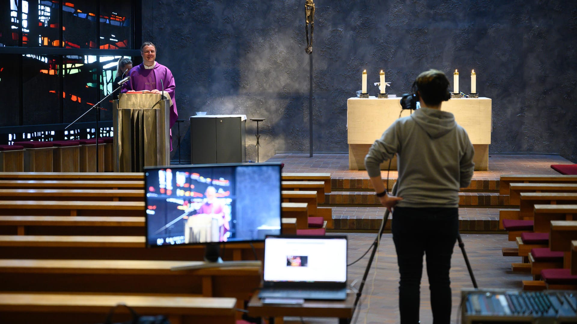 Messe im Stream: Ein Pfarrvikar leitet in einer leeren Kirche einen Gottesdienst, der auf YouTube gestreamt wird. Erstmals in der Geschichte des christlichen Abendlands gibt es weitreichende Gottesdienstverbote in mehreren europäischen Ländern.