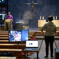 Messe im Stream: Ein Pfarrvikar leitet in einer leeren Kirche einen Gottesdienst, der auf YouTube gestreamt wird. Erstmals in der Geschichte des christlichen Abendlands gibt es weitreichende Gottesdienstverbote in mehreren europäischen Ländern.