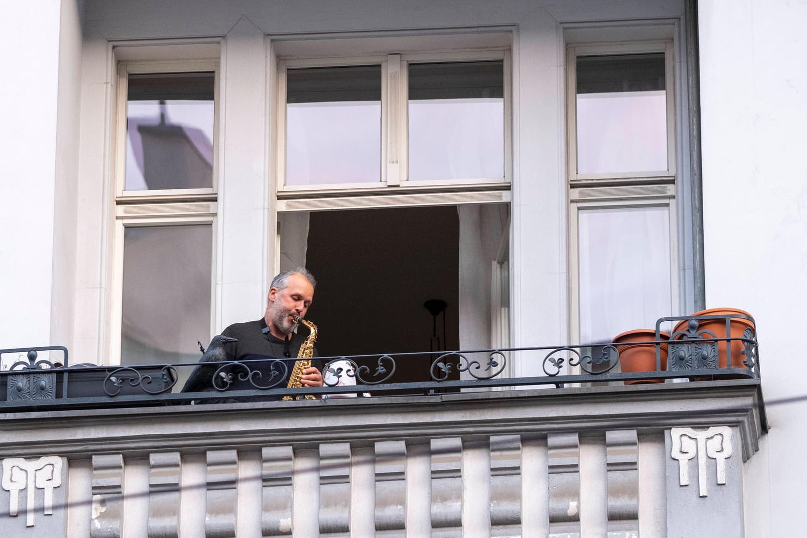 Ein Saxophonist spielt auf seinem Balkon: In Dortmund haben Musiker der Philharmoniker sich an ihre Fenster gestellt und musiziert.