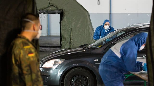 Ein Arzt nimmt bei einer von der Bundeswehr organisierten Drive-In-Teststation in Saarbrücken Abstriche. Ein Arzt nimmt bei einer von der Bundeswehr organisierten Drive-In-Teststation in Saarbrücken Abstriche.