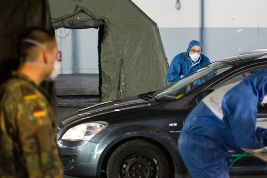 Ein Arzt nimmt bei einer von der Bundeswehr organisierten Drive-In-Teststation in Saarbrücken Abstriche.