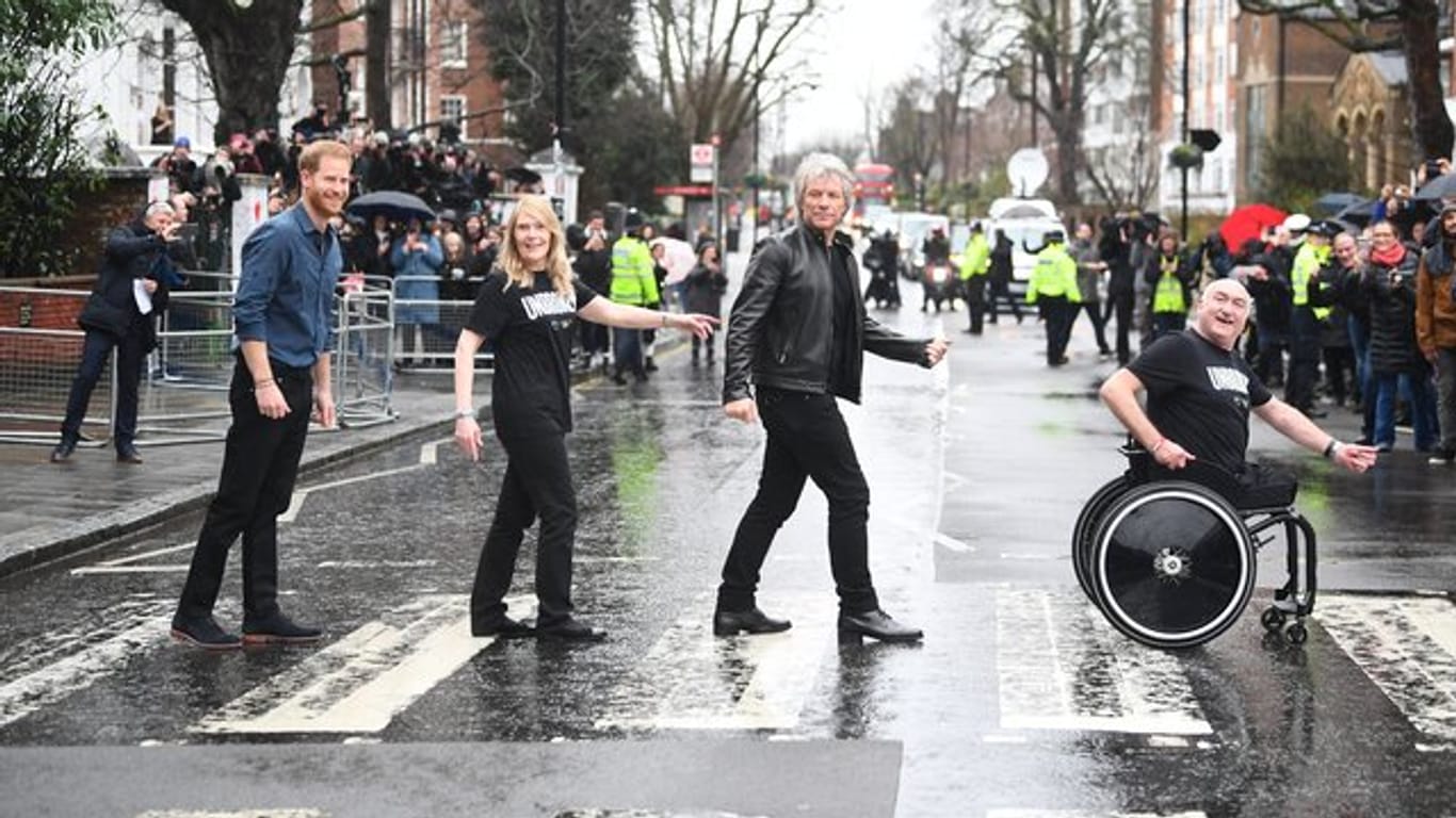 Jon Bon Jovi und Prinz Harry mit Mitgliedern des Invictus-Games-Chors auf dem berühmten Zebrastreifen vor den Abbey Road Studios.
