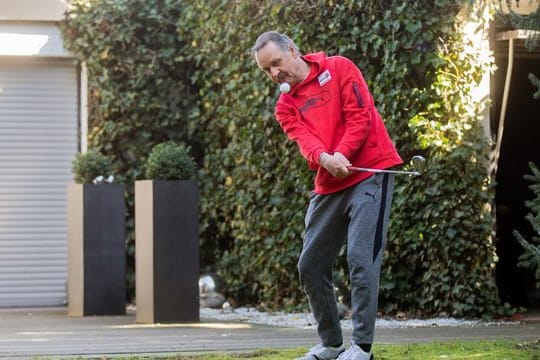 Peter Neururer übt in seinem Garten Golf.