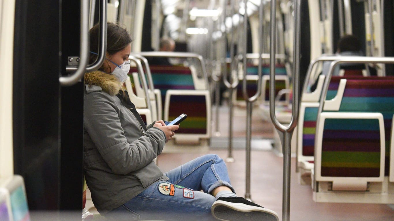 Eine Frau am Smartphone in der U-Bahn (Symbolbild): Im Kampf gegen das Coronavirus wird darüber diskutiert, Handydaten zu verwenden.
