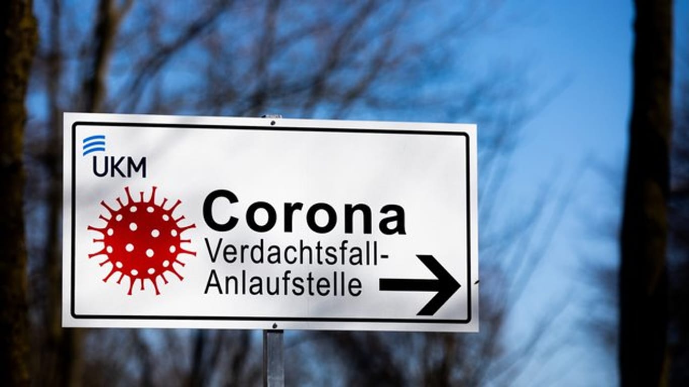 Ein Hinweisschild mit der Aufschrift "Corona Verdachtsfall-Anlaufstelle" steht vor der Uniklinik Münster.