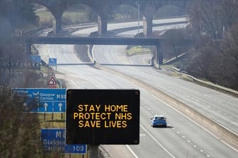 Eine digitale Anzeigentafel an einer Autobahn appelliert an die Fahrer, möglichst zu Hause zu bleiben.