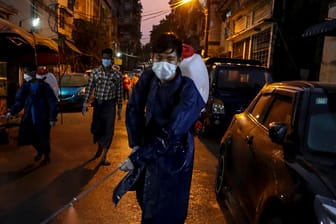 In Myanmar versprüht ein Mann auf der Straße Desinfektionsmittel: Die Corona-Krise hat die ganze Welt erreicht.