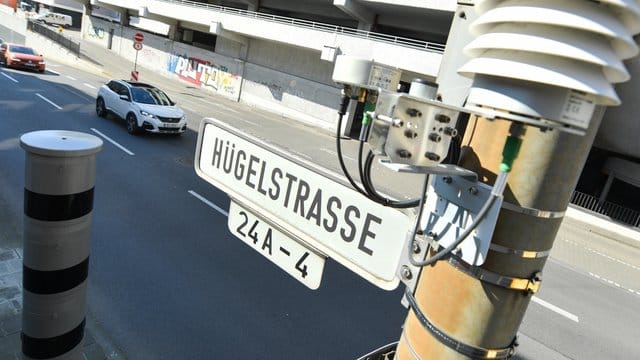 Autos fahren auf der Darmstädter Hügelstraße an einer Luftmessstation vorbei. Autos fahren auf der Darmstädter Hügelstraße an einer Luftmessstation vorbei.