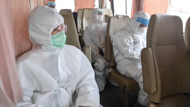 Haikou: Mitarbeiter in Schutzanzügen des Zolls sitzen in einem Shuttle-Bus, um Untersuchungen an neu eingetroffenen Fluggästen durchzuführen, um die Ausbreitung des Coronavirus einzudämmen.